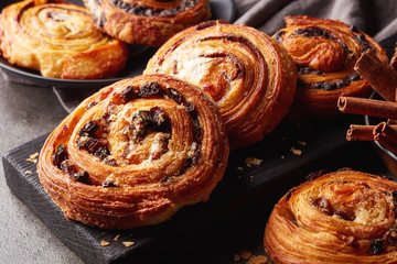 Sweet buns on black board isolated on stone table