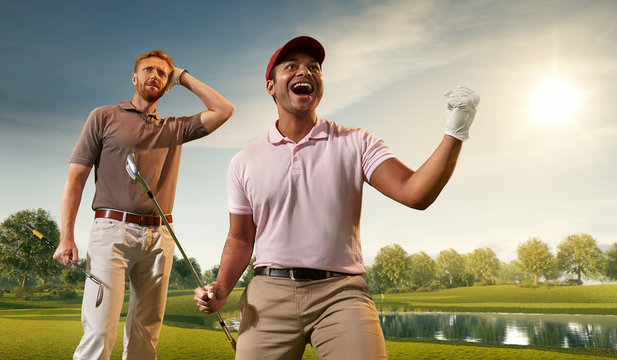 Two male golf players on professional golf course. Happy player emotionally rejoices victory. Opponent sad about losing