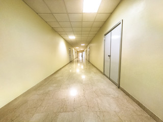 Generic white walkway corridor with white walls of a hospital lane interior. Blurred medical and healthcare background.