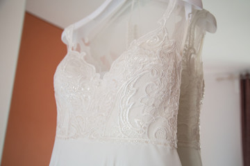 White beautiful bridal dress with lace on a wooden shoulders, before wedding ceremony