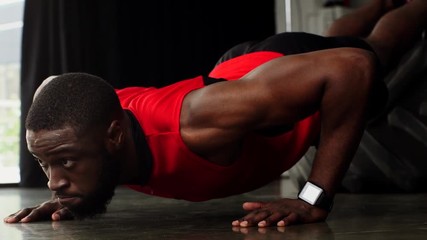 african american sportsman doing push ups at gym in slow motion