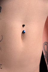 Bauchnabel mit Piercing in Nahaufnahme