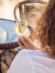 Young man drinking white Portuguese wine by an outdoor table in Tavira, Algarve region, Portugal