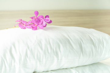 Fototapeta na wymiar Pillows and beautiful orchid flower on top in the bed room.