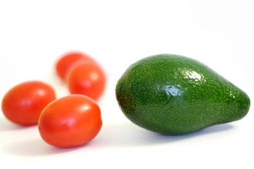 whole avocados with tomatoes on white background