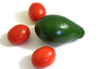 red tomatoes and green avocado on white background
