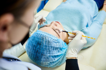 Fototapeta premium cosmetologist doctor does a wellness face cleaning for a young girl, cosmetology room, acne treatment