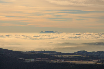 Sea of clouds with green mountains. Environmental phenomena concept