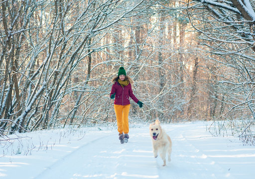 Portrait of a young woman with dog on winter walk.