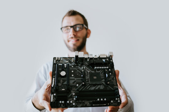 Computer Technician holding internal part of a desktop - Powered by Adobe