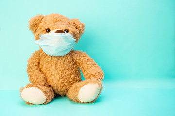Teddy bear with mask sit alone on white background,Sick concept