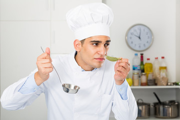 Young male is degustating soup