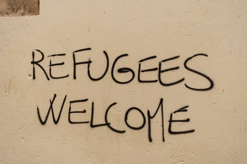 Graffiti with the political slogan "Refugees Welcome" on a wall in Venice in 2018.