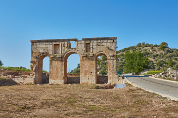 Fototapeta na wymiar The well preserved ancient triple arched Triumphal Arch located at the entrance to the Patara ancient city