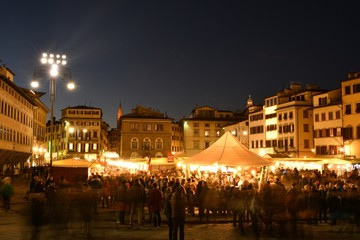 Fototapeta na wymiar Florence, ITALY - 8th December 2018: Tourists at Christmas Market in the centre of Florence near Basilica of Santa Croce. Christmas atmosphere with Sparkling lights, Italy.