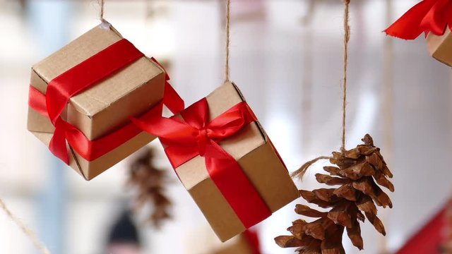 Hanging presents with red ribbon and pine cones in traditional Christmas market