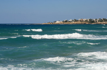 White foamy waves on a rocky shore of the Mediterranean sea