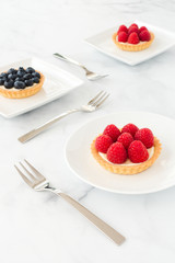 Raspberry and Blueberry Tartlets on White Plates