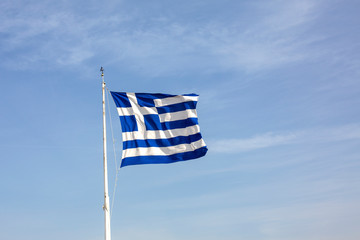 Greek flag on blue sky background. Acropolis, Athens, Greece. A gigantic Greek flag on the Athenian Acropolis. The national flag of Greece