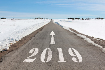 happy new year concept of snowy road heading to 2019