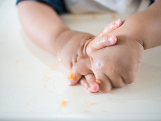 Dirty hands of little kid after have meal on the white table.