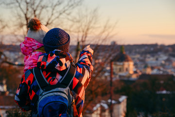 father with little daughter looking at old european city at sunset