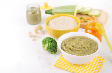 Different types of vegetable puree on the light background near ingredients