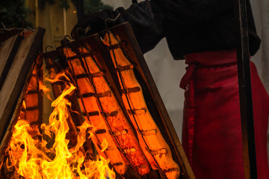 Der Grillmeister richtet die Holzbretter, auf denen Flammlachs am Feuer gegart wird