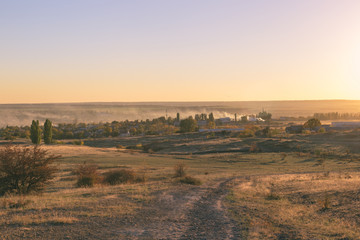 Smoke over the village in the autumn. Burning foliage in Ukraine.