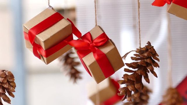 Hanging presents with red ribbon and pine cones in traditional Christmas market