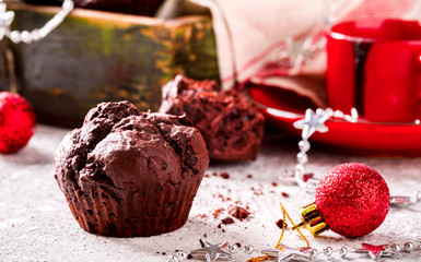 Chocolate Muffins in Christmas. Festive drink Hot Chocolate in a red cup on a light Background decorated with stars.