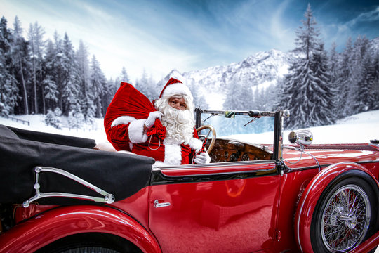 Santa claus in a red car on Christmas Eve evening  