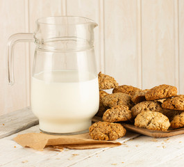 Oatmeal cookies with milk on tray on rustic wooden table