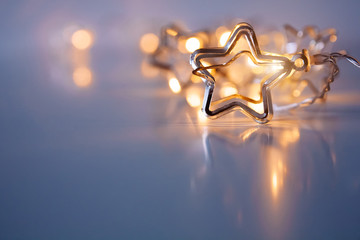 A stars shaped christmass garland on the table. Space for text