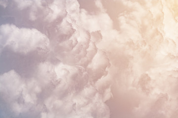 Cumulus fluffy clouds illuminated by orange sunlight  as background (abstract, toned)