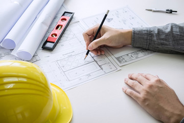 Construction engineering or architect hands working on blueprint inspection in workplace, while checking information drawing and sketching for architecture project working