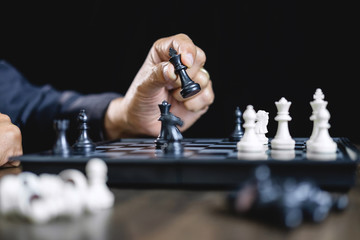 Businessman playing chess and thinking strategy about crash overthrow the opposite team and development analysis for win and successful