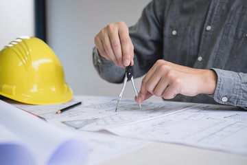 Construction engineering or architect hands working on blueprint inspection in workplace, while checking information drawing and sketching for architecture project working