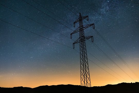 Strommast bei Sonnenuntergang mit der Milchstra&szlig;e