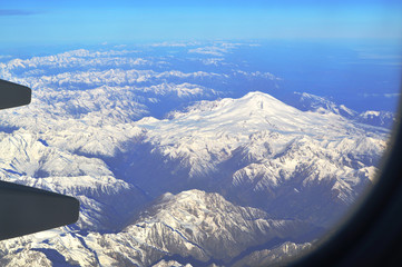 The view from the window of an airplane over the mountains of the Caucasus