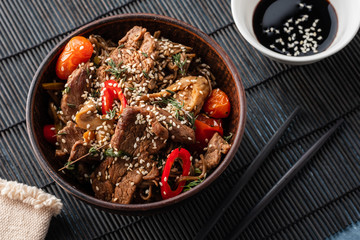 Soba noodles with beef, mushrooms, cherry tomato and sweet peppers. Asian cuisine