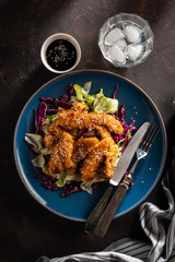 Salad with warm glazing chicken, sprinkled with sesame seeds. Chinese cuisine. Asian culture