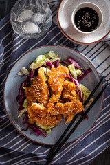 Salad with warm glazing chicken, sprinkled with sesame seeds. Chinese cuisine. Asian culture