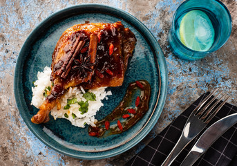 Duck leg confit with rice and goji berries. Traditional french cuisine. View from above.