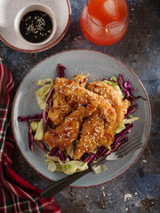 Salad with warm glazing chicken, sprinkled with sesame seeds. Chinese cuisine. Asian culture