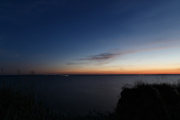 Colorful sunset on the river Bank. Blue dark night sky