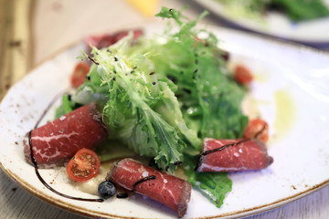 Plate with marbled beef salad