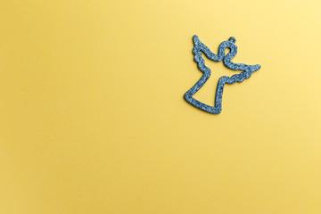 Christmas angel on yellow background. Symbolic image. Christmas background. Copy space. Top view. Flat lay. Concept holiday