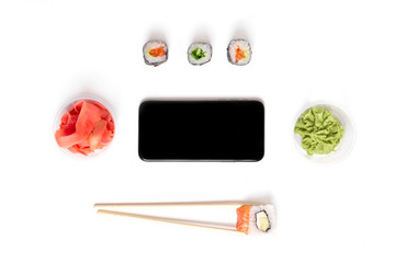 sushi set rolls on white background chopsticks wasabi ginger phone delivery food concept