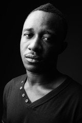 Young African man against black background in black and white